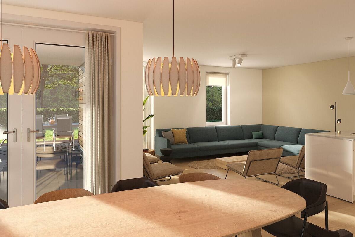 A modern living space with a dining area, a sofa, and a kitchen.