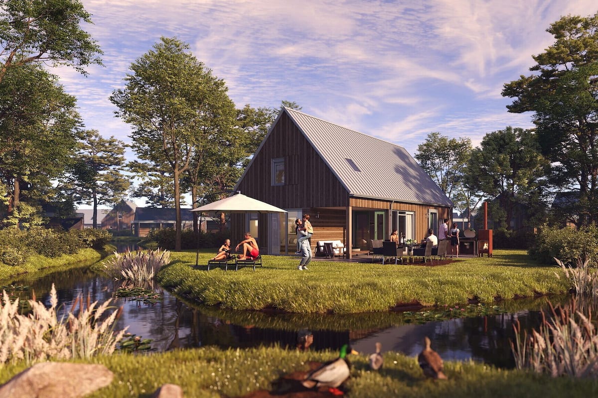 A rustic wooden house with a large porch, surrounded by a pond and trees.