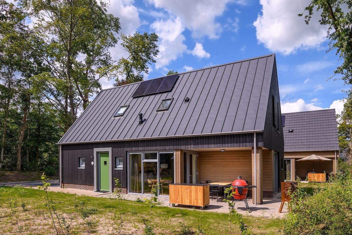 A modern house with a sloped roof, large windows, and a garage.
