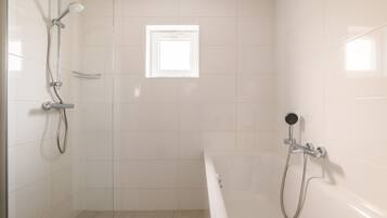 Un bagno con doccia, vasca e finestra.