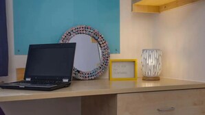 A desk with a laptop, a framed quote, a decorative mirror, and a lamp. - Student Only Knoll Court (Newcastle-upon-Tyne)