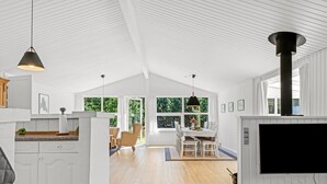 Amplia habitación, bien iluminada, con techo alto, ventanas grandes y una cocina moderna.