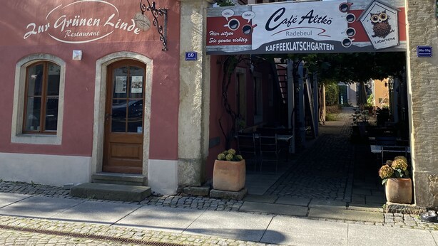 Un edificio tradicional con un cartel que dice 'Café Altko' y un cartel más pequeño que anuncia 'Restaurante 2. Grüne Linde'.