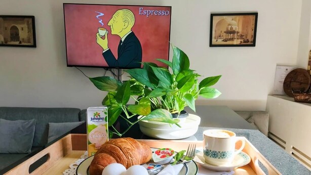 A breakfast tray with croissants, eggs, a cup of coffee, and a plant. - marhaba inn (Cairo)