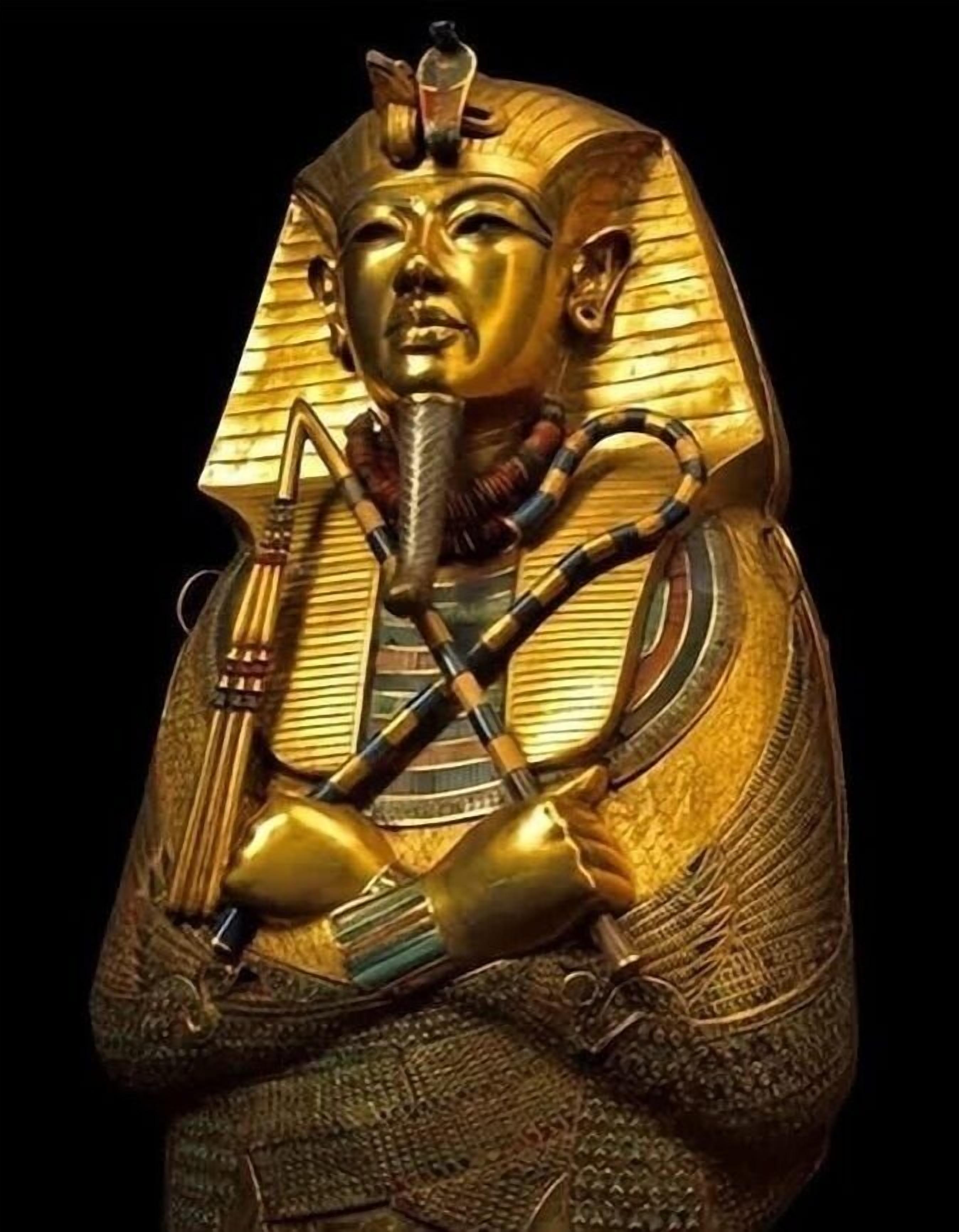 A golden statue with a headdress, a staff, and a bird.