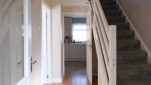 A hallway leading to a kitchen with a staircase. - Modern 3BR Family Home w/ Garden | Luton (Luton)