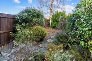 Explore a serene garden oasis with a winding stone pathway and lush greenery.