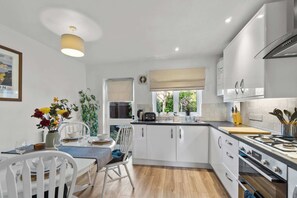 Enjoy cooking in this well-equipped kitchen with a central island, stove, oven, and sink.