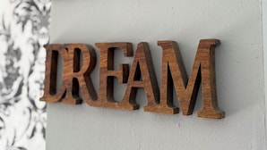 Wooden letters spelling "LOVE DREAM" on a wall. - Hotel B and B Suites (Benidorm)