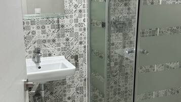 Eenvoudige kamer | Badkamer | Een douche, handdoeken, shampoo, toiletpapier