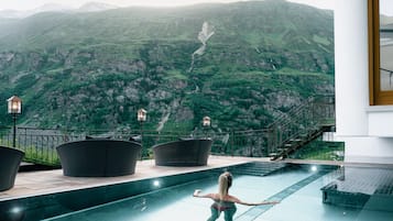 Een binnenzwembad, een buitenzwembad en parasols bij het zwembad