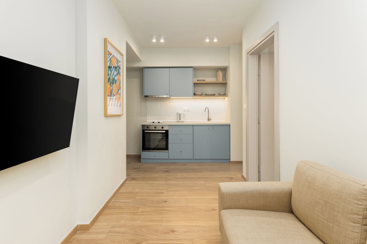 A modern kitchen with blue cabinets, a built-in oven, and a sink.