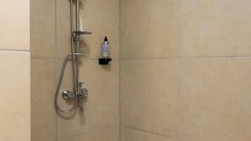 A shower with a handheld showerhead and a wall-mounted rain showerhead.
