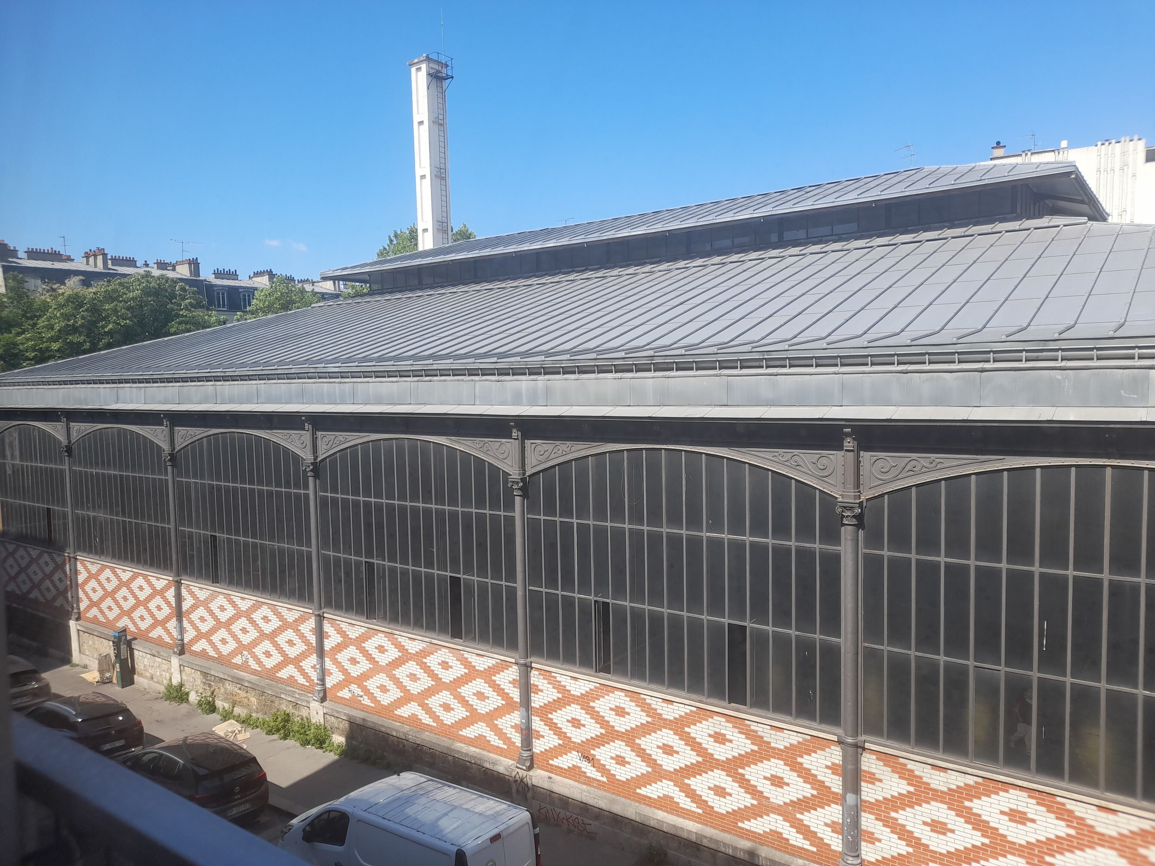 A building with a large glass facade and a patterned tile design on the lower section.