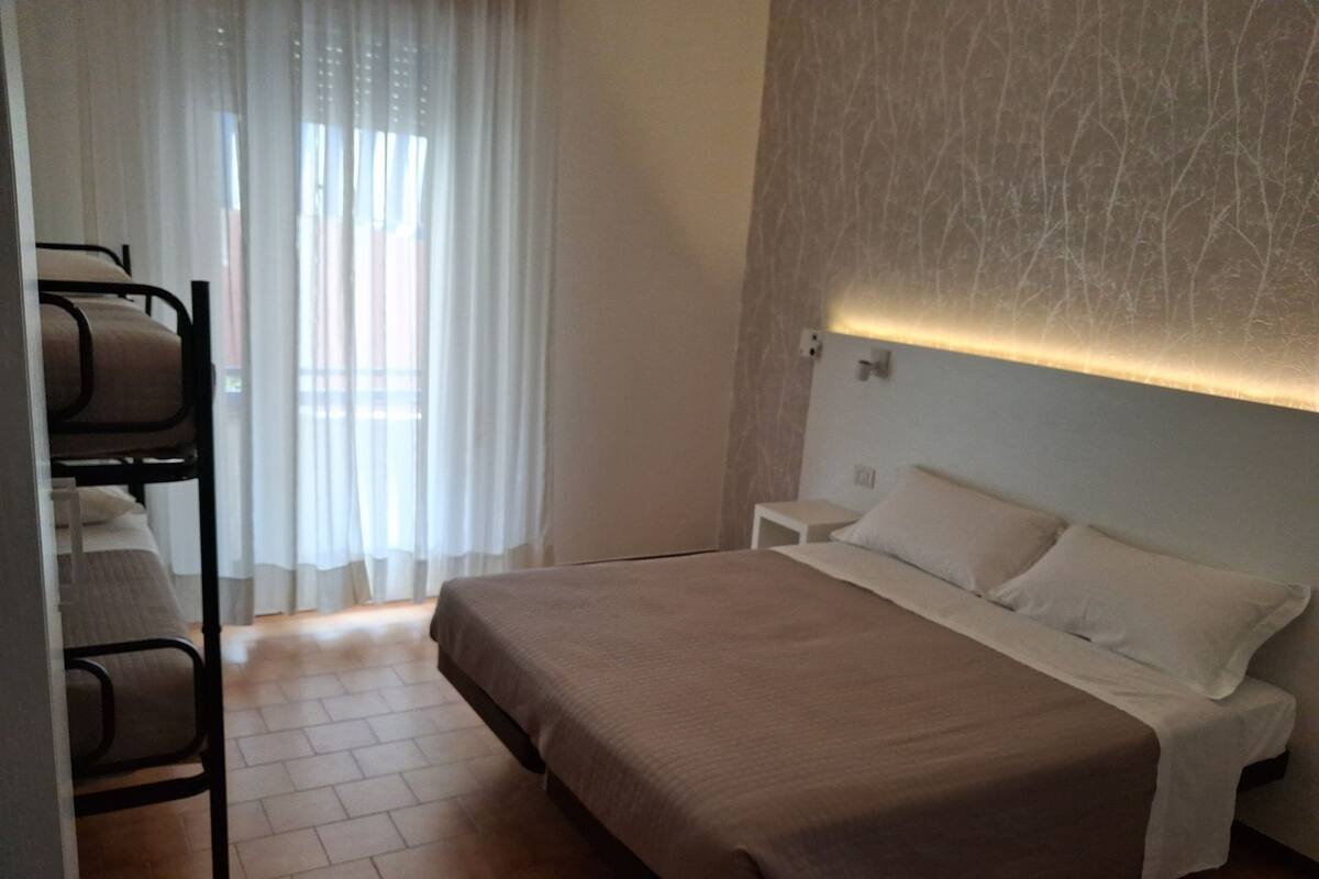 A bedroom with a bed, a nightstand, and a chair.