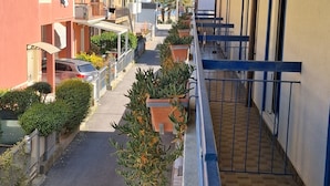 A residential street with houses, a parked car, and potted plants along the sidewalk. - Hotel Conca d'Oro (Rimini)