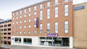 Un immeuble à plusieurs étages avec une façade en briques, une enseigne « Premier Inn » et un panneau indiquant un parking.