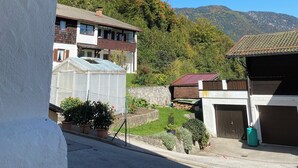 Ein Wohngebiet mit Hausnummernschild, Garage und Blick auf einen Berg.