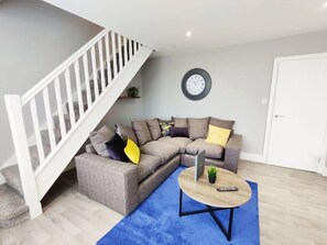 Relax in this stylish living room with a grey sofa, coffee table, and a cozy rug.