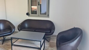 Een kamer met een zithoek, een salontafel en een raam met uitzicht.