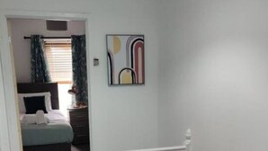 A hallway with a staircase leading to a bedroom. - 3 Bed • Parking • Smart TV`s • Great for Work (Clydach)