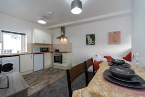 Enjoy a well-equipped kitchen with oven, microwave, and range hood, perfect for cooking and dining.
