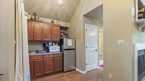 Una cocina con armarios de madera, microondas y refrigerador.