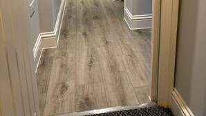 A hallway with a wooden floor, light grey walls, and a door at the end. - Contractor Stay • 2 Bed • 2 En-suites (Swansea)