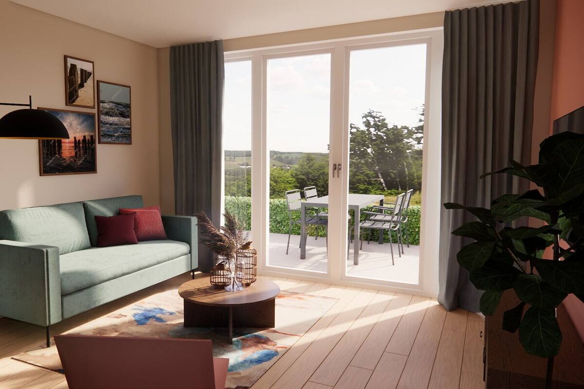 A modern living room with a green sofa, a coffee table, and a large window with a view of greenery.