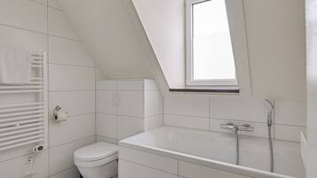 A modern bathroom with a skylight, a bathtub, a toilet, and a towel rack.