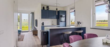 A modern kitchen with dark cabinets, a central island, and bar stools.