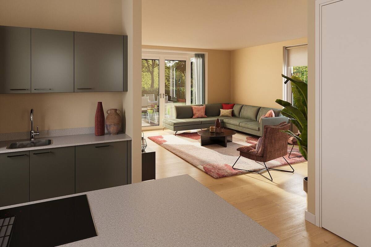 A modern kitchen with grey cabinets, a sink, and a dining area with a table and chairs. There is a living room with a sofa, a coffee table, and a chair. A large plant is visible in the corner.
