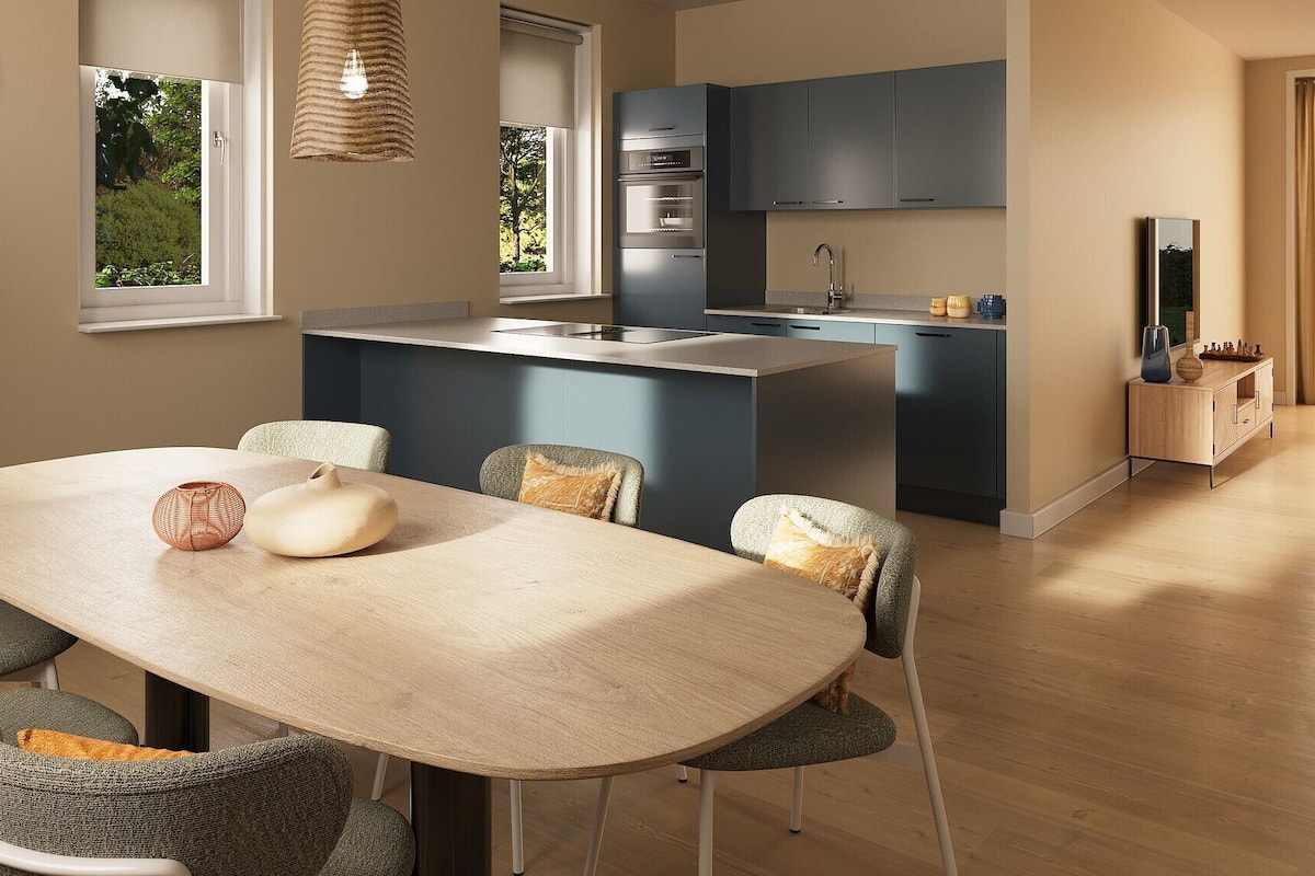 A modern kitchen with dark cabinets, a built-in oven, and a sink.