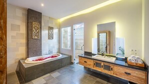A modern bathroom with a freestanding bathtub, a large mirror, and a wooden vanity. - Villa Nora by Five Elements (Canggu)