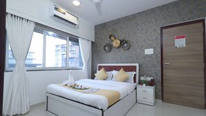 Una habitación de hotel con una cama, mesita de noche y una bicicleta fijada a la pared.