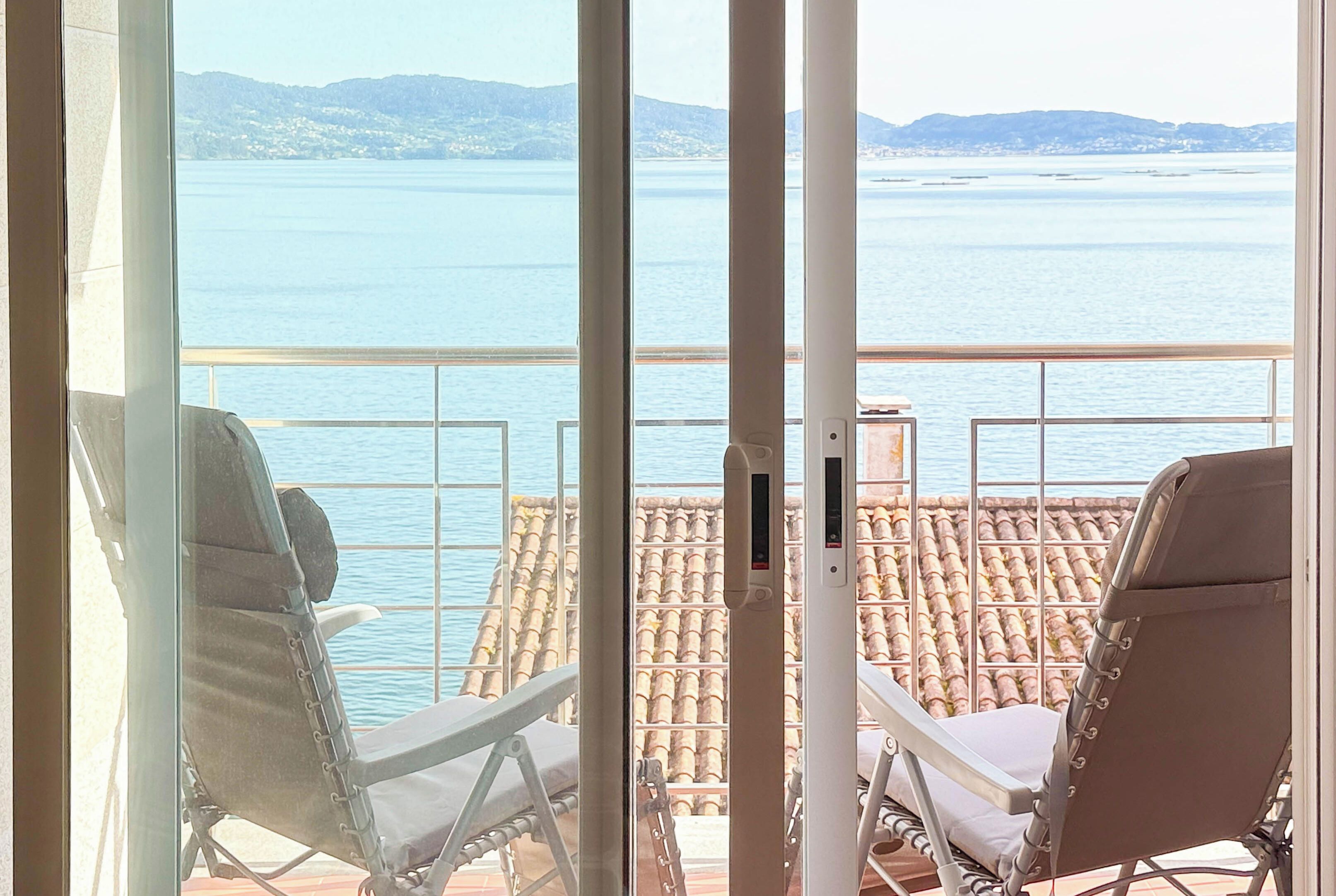 Un balcon avec deux fauteuils confortables donnant sur la mer.