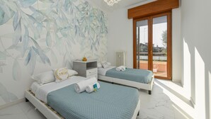 Une chambre moderne avec deux lits, une grande fenêtre et une fresque murale décorative.