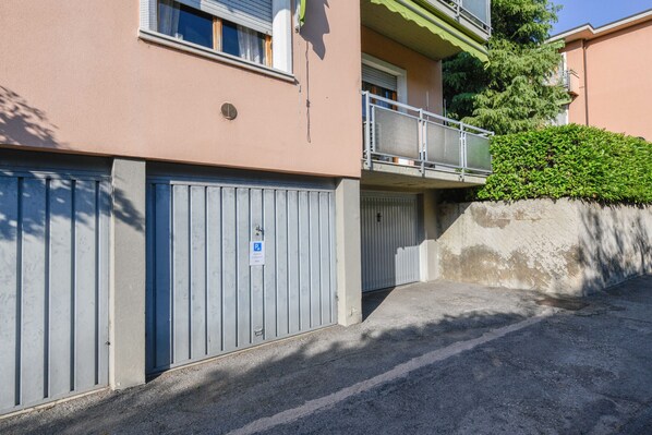 A building with a garage door, a balcony, and a small tree. - MGH- My Desenzano Center Apartment (Desenzano del Garda)