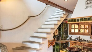 A staircase with stone steps leading to a kitchen area with wooden cabinets and a stove. - Beautiful apartment for 4 people with pool, WIFI, TV, patio, pets allowed and panoramic view (Orselina)