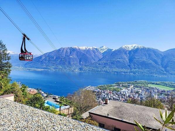 A cable car with a view of a lake and mountains in the background.