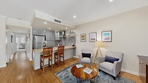 A modern apartment with a kitchen, dining area, and living room.