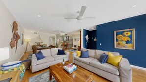 A living room with two sofas, a coffee table, and a dining area with chairs.