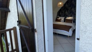 Un dormitorio con cama, almohadas y una lámpara colgante.