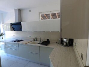 Una cocina moderna con una isla central, armarios empotrados y un ventanal sobre el fregadero.