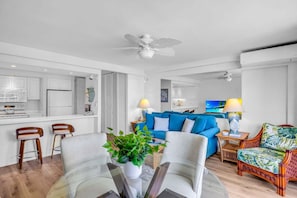 A modern living room with a blue sofa, a coffee table, and a TV.
