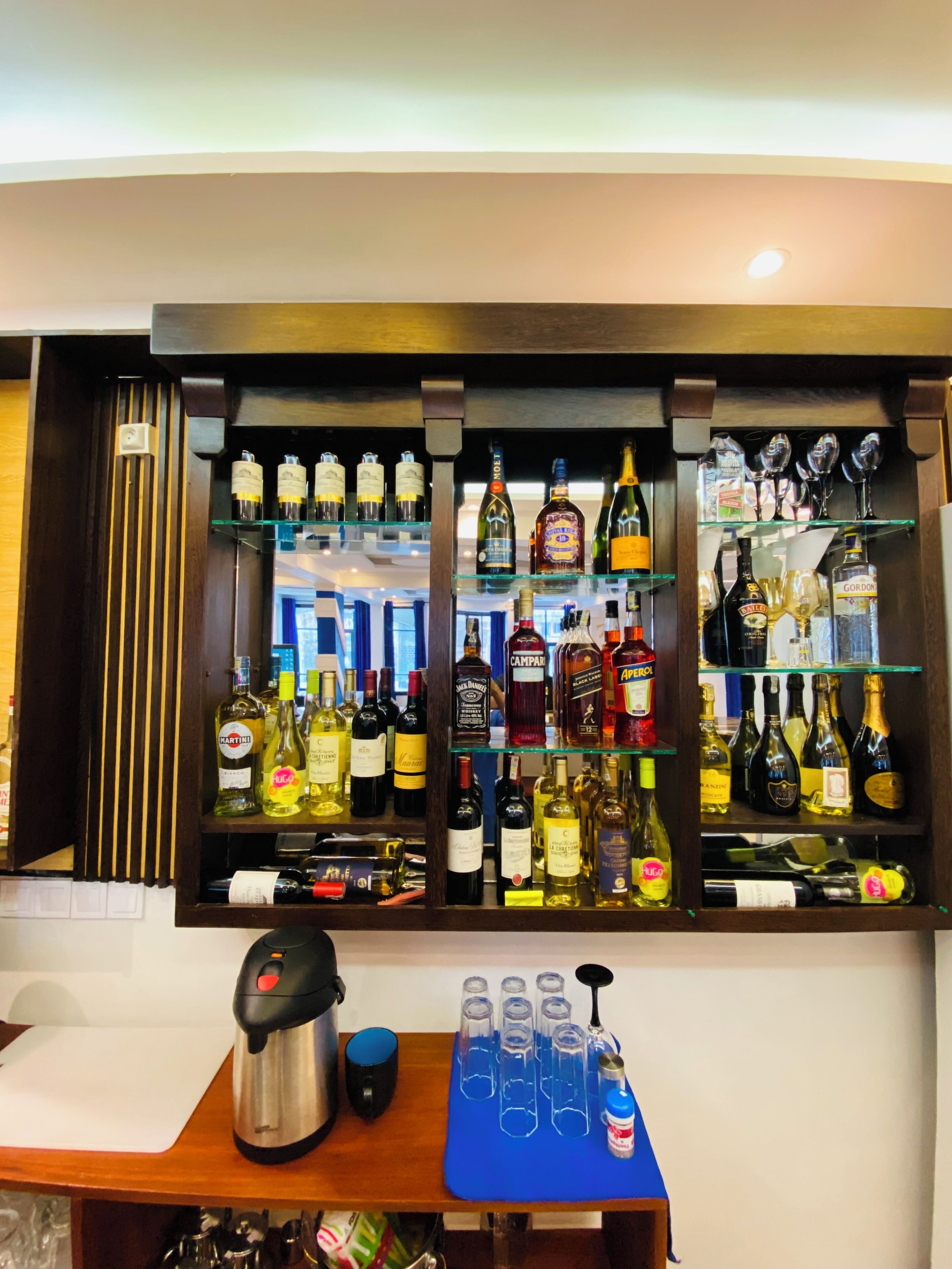 A bar area with shelves of liquor bottles and glasses.