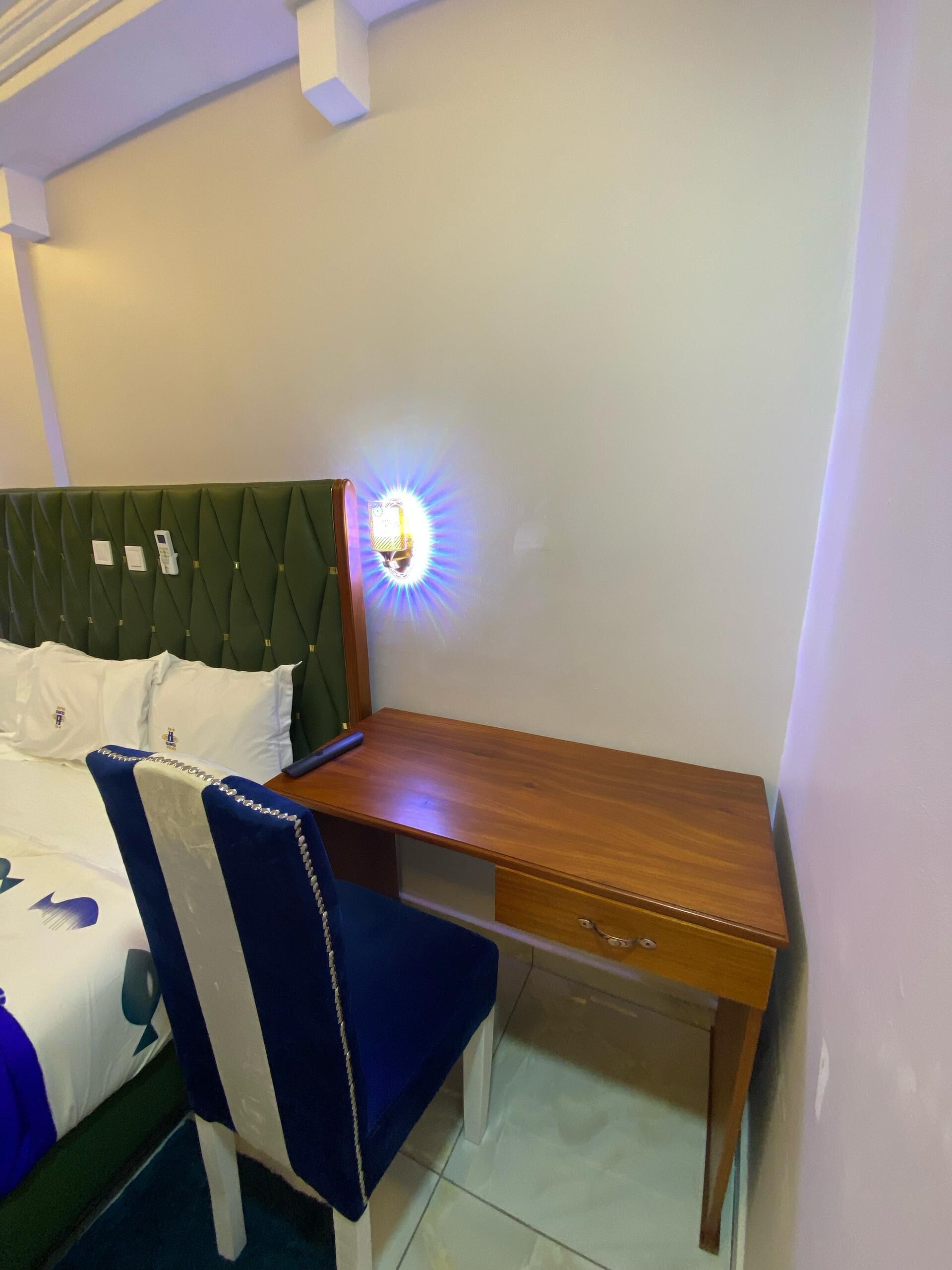 A bedroom with a bed, a desk, and a chair.