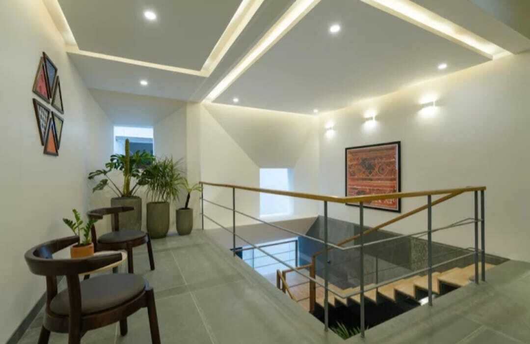 A modern interior with a staircase, potted plants, and artwork on the walls.