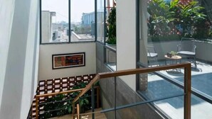 Ein modernes Interieur mit Glasdach, Treppe und Blick auf die Stadt.
