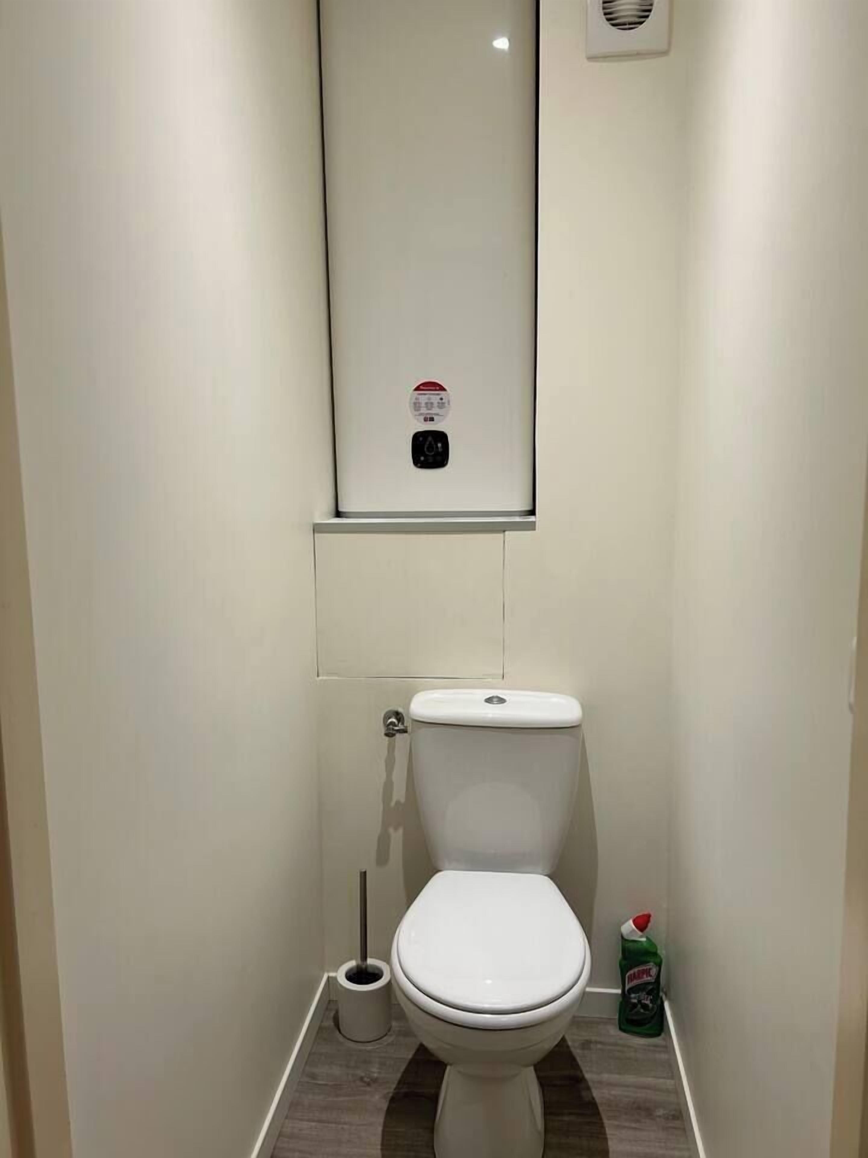 Ein kleines, sauberes Badezimmer mit Toilette, Bidet und Handtrockner.